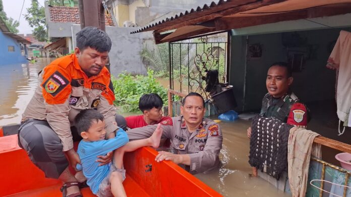 Polisi membantu warga evakuasi